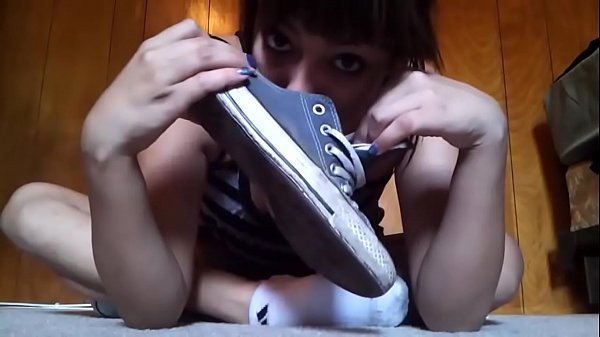 Beautiful girl takes off her converse and socks to show her rich sweaty feet.
